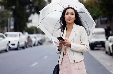 Image showing Woman, city and smartphone with umbrella, thinking or lost with connection, network or insurance. Female person, girl or cellphone with cover, outdoor or walking in the street, search or website info