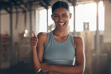 Image showing Woman in gym, thumbs up with wink in portrait, like fitness with emoji and health goals with sport and mockup space. Hand gesture, yes and motivation with Indian female athlete at exercise studio