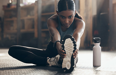 Image showing Woman is stretching legs in gym, fitness and start workout with focus, sneakers and sport preparation. Health, active with serious Indian female warm up and ready for exercise with determination