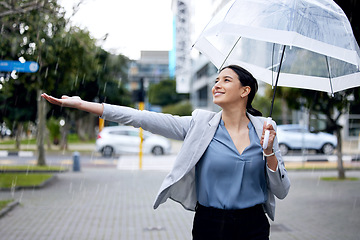 Image showing Rain, happy and woman in winter with an umbrella or cold weather in a city street or road and travel in urban town. Corporate, young and employee walking in happiness with a smile in the morning