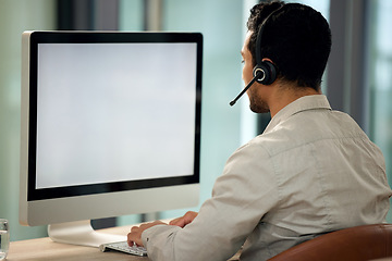 Image showing Call center, man and back with computer, typing and blank screen for copy space, telemarketing and mockup. Young male consultant, pc and customer service with advice, email or communication in office