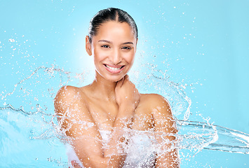 Image showing Water, splash and beauty with portrait of woman in studio for hygiene, shower and skincare. Wellness, cleaning and fresh with face of female model on blue background for spa, cosmetics and liquid