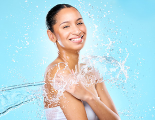 Image showing Water, splash and spa with portrait of woman in studio for hygiene, beauty and skincare. Wellness, cleaning and fresh with face of female model on blue background for shower, cosmetics and liquid