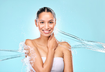 Image showing Water, splash and skincare with portrait of woman in studio for hygiene, beauty and shower. Wellness, cleaning and fresh with female model on blue background for spa, cosmetics and mockup space