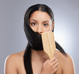 Image showing Woman, portrait and brush in studio for hair grooming, salon or style against a grey background. Female person, young model and clean beauty for brushing, haircare treatment and smooth texture