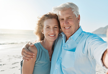 Image showing Senior, couple and selfie at the beach with portrait for happiness on holiday for the weekend. Mature, woman and man hug at the ocean for closeup and smile in the outdoor on vacation for retirement.