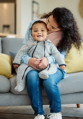 Image showing Kiss, portrait and mother with baby in living room home, bonding or having fun in house. Mom, newborn and kissing face of happy child on sofa for care, love and affection for family time together.