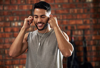 Image showing Fitness, earphones and music, man in gym listening to streaming service for motivation podcast and smile. Exercise, workout and happy bodybuilder, online radio or audio for healthy mindset in club.