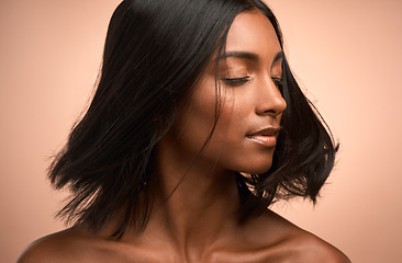 Image showing Motion, beauty and woman in studio with a hair care, keratin and healthy salon treatment. Wellness, luxury and female model shake her shiny, clean and soft hairstyle or haircut by a brown background.