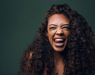 Image showing Natural beauty, tongue out and wink by gen z girl with hair, curly and fun on green background. Afro, hair care and female model flirt, emoji and silly face, personality or youth aesthetic in studio