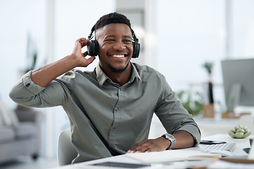 Image showing Black man, headphones and listening to music in office with smile for sound track or podcast. Happy African male person or professional designer smiling with headset enjoying audio at the workplace