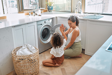 Image showing High five, laundry and washing machine with mother and daughter for helping, learning and cleaning. Housekeeping, teamwork and basket with woman and young girl in family home for teaching and clothes