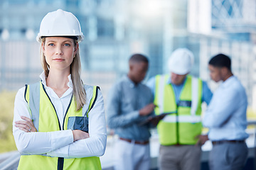 Image showing Portrait, arms crossed and a serious woman construction worker outdoor on a building site with her team in the background. Management, leadership and a confident female architect standing outside