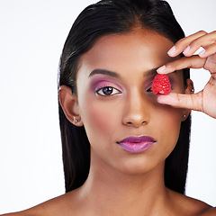 Image showing Woman, skincare wellness and raspberry in studio portrait for glow, color makeup or cover eye by white background. Indian model girl, skin health or fruit for cosmetic, healthy nutrition or aesthetic