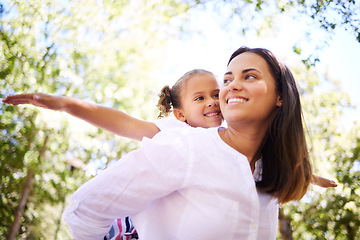 Image showing Child, mother and family outdoor in nature for piggyback in summer with happiness, love and care. Woman and girl kid playing together with arms out at a park for adventure, quality time and freedom