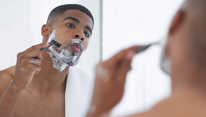 Image showing Man is shaving with cream, mirror and beauty, hair removal for hygiene and grooming during morning routine at home. Male person in bathroom, razor to shave and foam with fresh and clean skincare