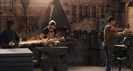 Image showing Hammer, anvil and sparks with a men working in a foundry for metal work manufacturing or production. Industry, welding and trade with a blacksmith people in a workshop, plant or industrial forge