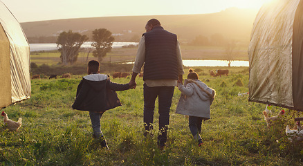 Image showing Family, holding hands and a man walking on a farm with his kids for agriculture or sustainability. Back, farming and a father with children in meadow as a cow farmer in natural countryside at sunset