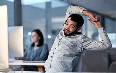 Image showing Call centre, tired and man stretching in office for telemarketing, customer service and sales consultant at night. Lazy, sleepy and frustrated male agent with burnout, fatigue and bored of consulting