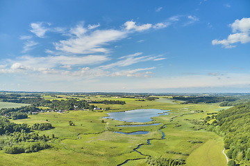 Image showing Nature, lake and environment with drone of countryside for agriculture, farming and summer. Grass, travel and landscape with aerial view of meadow field and blue sky for growth, plants and ecology