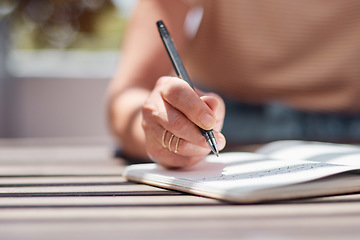 Image showing Hand, journal and book with a woman writer sitting outdoor in summer for inspiration as an author. Idea, planning and notebook with a female person using a pen to write in a planner or diary outside