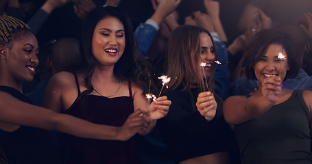 Image showing Dance, party and night with women and sparklers in club for music, celebration and concert. Festival, disco and fireworks with diverse friends dancing at social event for energy, techno and dj show