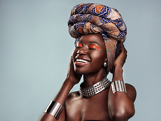 Image showing Beauty, black woman and smile with African head scarf and mockup in a studio. Isolated, blue background traditional Africa turban with a young female model with culture and pride with cosmetics
