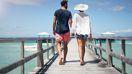 Image showing Couple, walking and Maldives pier on a tropical island on vacation with freedom by sea. Ocean, beach and deck walk of man back and woman together with love in summer on a holiday outdoor in sun