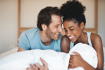 Image showing Happy couple, bed and laughing in relax for morning, bonding or intimate relationship at home. Interracial man and woman smiling with laugh in joyful happiness or relaxing weekend together in bedroom