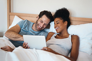 Image showing Happy couple, tablet and laughing in bed for funny entertainment, joke or morning in relax together at home. Interracial man and woman person with laugh on technology for social media meme in bedroom