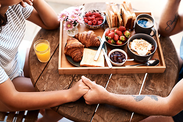 Image showing Cafe food, breakfast and couple holding hands for support care, bonding or love on Valentines Day date. Morning, romantic people and brunch tray of croissant, strawberry or bread in coffee shop store