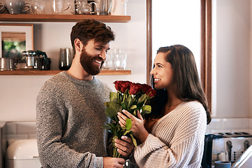 Image showing Flowers, surprise gift and happy couple with roses, floral present or flower bouquet for Valentines Day in home kitchen. Wow, bonding and romantic man with love present, care and enjoy quality time