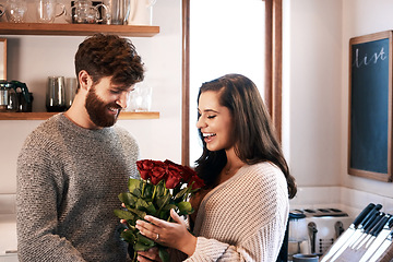 Image showing Rose, surprise and happy couple with flowers, floral present or flower bouquet for Valentines Day in home kitchen. Birthday happiness, support and romantic man with love gift for marriage anniversary