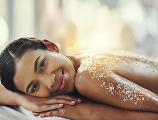 Image showing Happy woman, portrait and relax at spa in salt scrub for body treatment, skincare or massage at resort. Calm female face lying on bed in relaxation with smile for exfoliation, zen or therapy at salon