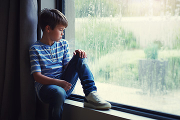 Image showing Boy child, rain and sad by window with thinking, mental health and space for mockup in home. Male kid, raining and think by glass with depression, mock up or bored with problem, winter or frustration