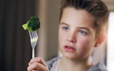 Image showing Disgust, food and refuse with child and broccoli for nutrition, health and cooking. Sad, angry and dinner with boy and green vegetable on fork at home for eating problem, frustrated and dislike