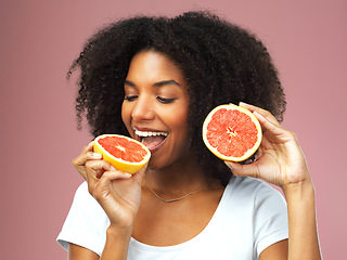 Image showing Grapefruit, happy and black woman eat in studio isolated on a pink background. Natural, fruit and African female model eating food for vegan nutrition, vitamin c or healthy diet, hungry and wellness.