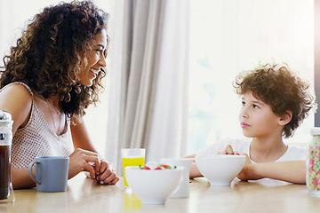 Image showing Family, breakfast and kid with mother at morning in a home with happiness and orange juice with care. Mom, food and young child together with love and support with healthy drink and youth with smile