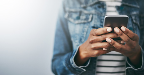 Image showing Hands, cellphone and woman with texting by wall background with typing, mockup space or email on web. Student girl, smartphone and chat for blog, post or video on social network app for communication