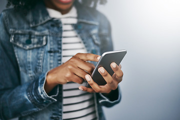 Image showing Hands, phone and woman with chat by wall background for typing email, contact or texting on internet. Student girl, smartphone and web for blog, post or video on social network app for communication