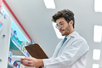 Image showing Pharmacist, clipboard and a man in pharmacy or working in a store for retail career. Male person in pharmaceutical or medical industry for service, healthcare and reading to check inventory on shelf