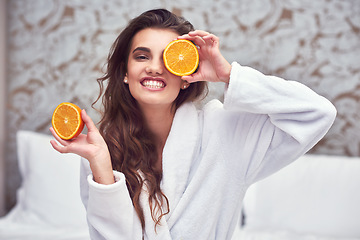 Image showing Orange, beauty and happy with woman in hotel for breakfast, diet and relax. Nutrition, health and natural with female person and cover face with citrus fruit in bedroom for vitamin c, spa and facial