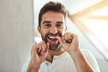 Image showing Dental floss, teeth and smile with portrait of man in bathroom for cleaning, morning and oral hygiene. Happy, cosmetics and health with face of person flossing at home for self care, breath and mouth
