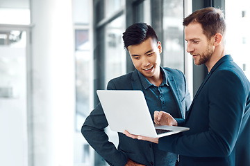 Image showing Technology, colleagues with a laptop and at a modern office together at their workplace. Connectivity or social networking, teamwork or collaboration and coworkers with help at workspace with smile