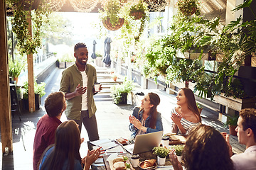 Image showing Applause, restaurant and black man with business people in meeting for lunch discussion, planning and success. Cafe, teamwork and men and women clapping for winning, collaboration and achievement