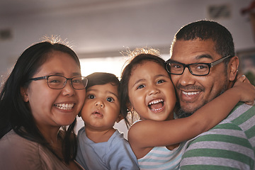 Image showing Portrait, laugh and happy family hug in a living room, excited and bonding in their home together. Face, children and parents in a lounge embrace, relax and laughing at funny, comedy and crazy joke