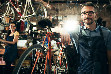 Image showing Serious, portrait and mechanic man in bicycle shop working in store or cycling workshop for repair. Face, bike technician and confident male person, worker or mature professional with glasses.