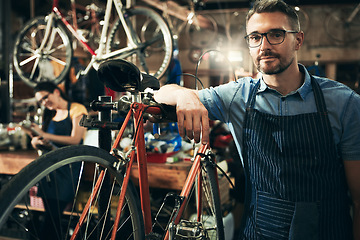 Image showing Portrait, serious man and mechanic in bicycle shop, store and cycling repair startup. Technician service, bike and confident male person, mature worker and professional with glasses in workshop