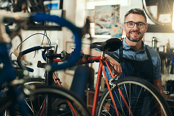 Image showing Portrait, happy and repair man in bicycle shop for working in store, cycling workshop and startup. Confident bike mechanic, small business owner and mature male technician with glasses in Australia