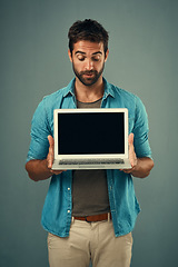 Image showing Man, laptop and mockup screen for advertising or marketing against a grey studio background. Male person holding technology or computer display, mock up or copy space for branding or advertisement